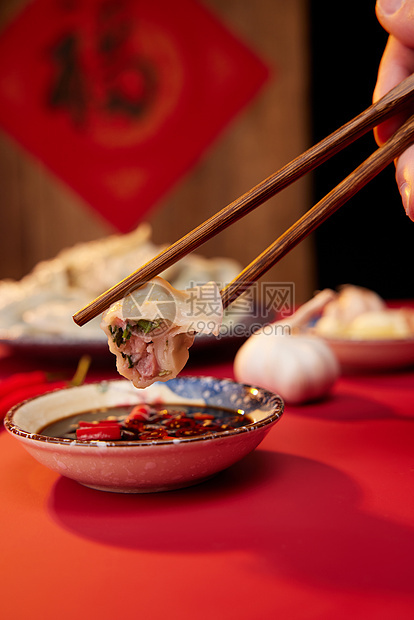 筷子夹起水饺蘸醋特写图片