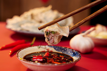 筷子夹起水饺蘸醋特写图片