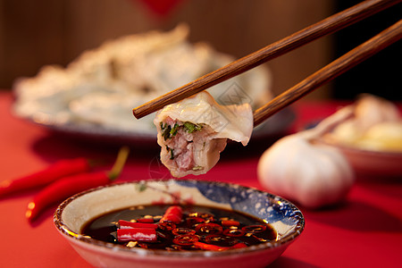 冬至祝福拿筷子夹饺子蘸酱油醋特写背景