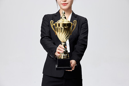 手拿奖杯获奖的商务女性图片
