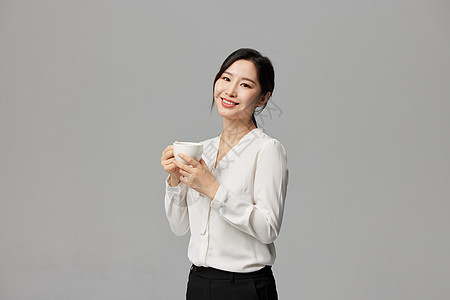 商务女白领手拿咖啡杯背景图片