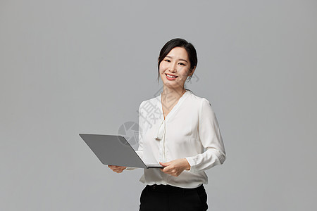 手拿笔记本电脑自信的商务女性图片