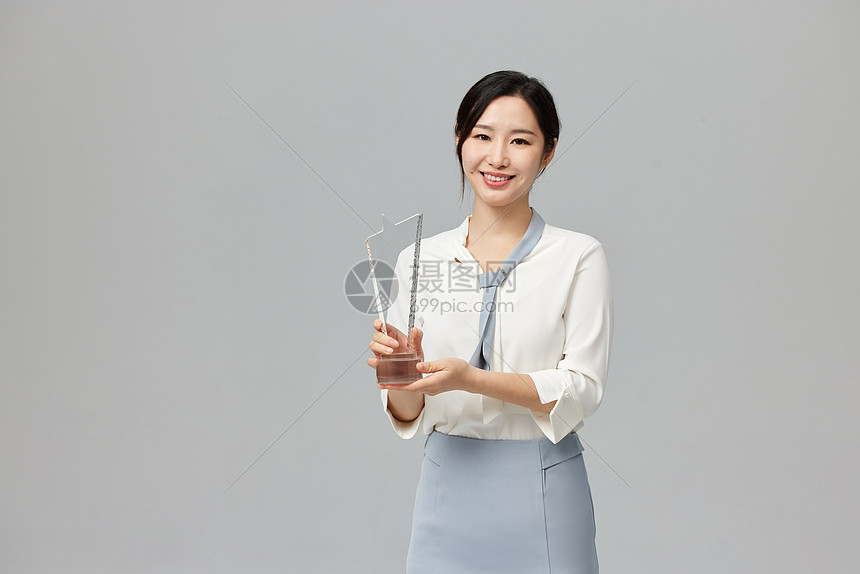 手拿奖杯的成功女性图片