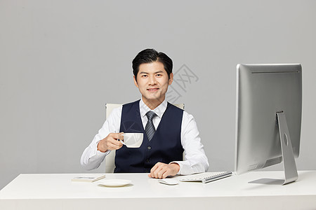 年轻商务男士在办公室喝咖啡图片