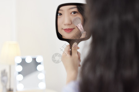 照镜子化妆的年轻美女高清图片