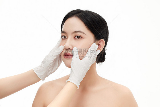 整形医生用手抚摸确认女人的脸部状态图片