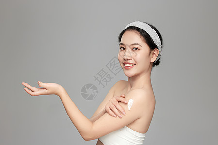 模特微笑向镜头展示手臂上擦的身体乳图片