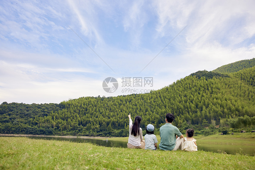 一家四口坐在草地上的背影图片