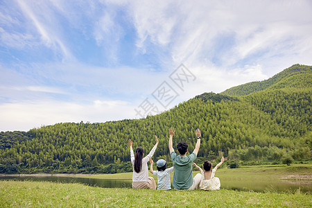 一家人坐在草地上背景