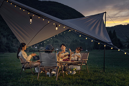 在户外野餐的一家人户外露营幸福的一家人温馨的在聊天背景