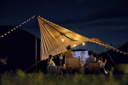 暑假去哪儿一家人在帐篷下看电影背景