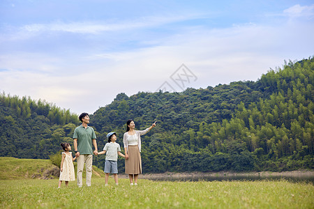 在户外野餐的一家人爸爸妈妈戴着两个孩子在玩耍背景