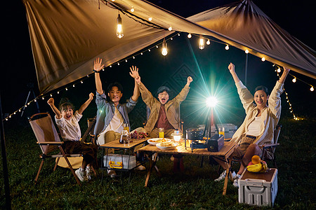 一家人喝水户外露营一家人举起手来快乐的拍照背景