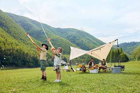 户外露营两个孩子玩水枪背景图片