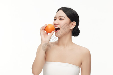 张开嘴巴摆拍吃水果的模特形象高清图片