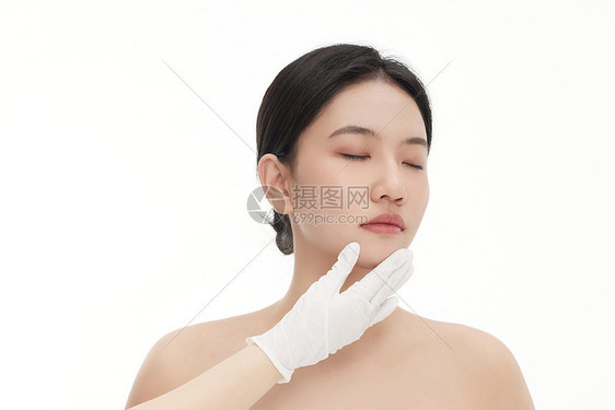 整形医生正在用手确认女人下巴的状态图片