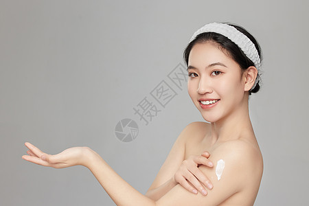 微笑展示手臂上身体乳的年轻女孩图片