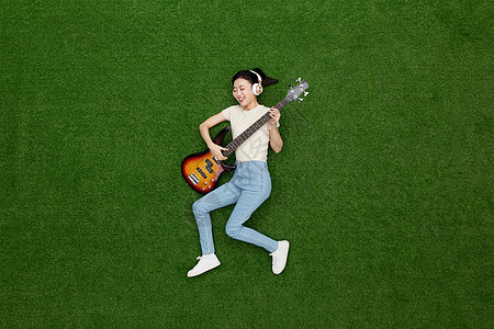 创意俯拍拿着电吉他大笑的年轻美女图片