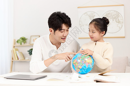 儿童互动拿着地球仪的爸爸正温柔给女儿讲解地理知识背景