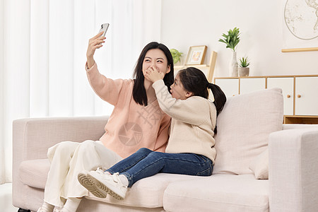 沙发上搞怪自拍的可爱母女高清图片