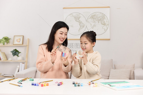 正拿着水彩颜料认真画画的母女俩图片