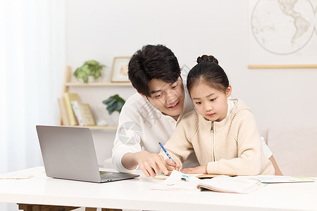 正辅导女儿完成作业的年轻爸爸图片