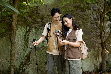 徒步旅行的年轻情侣拿相机拍摄图片