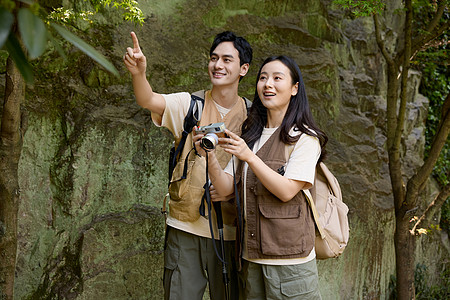 徒步旅行的年轻情侣拿相机拍摄背景