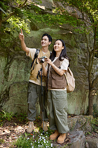 情侣拿相机拍照徒步旅行的年轻情侣拿相机拍摄背景