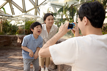 爸爸给儿子和妻子在植物园拍照图片