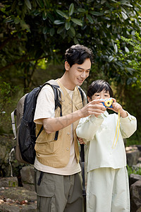 陪伴老人爸爸教儿子如何用相机拍山景背景