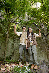 一对情侣在山上举着登山杖摆拍图片