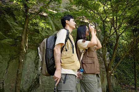 一对情侣拿着相机在拍山上景色图片