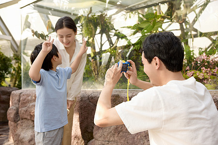 植物园里微笑拍照的一家人图片