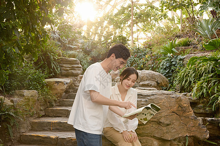 年轻情侣在植物园里看书图片