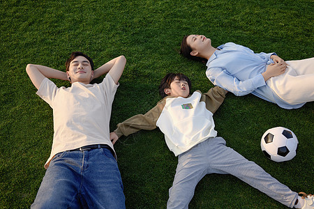 一家三口在草坪上休息图片
