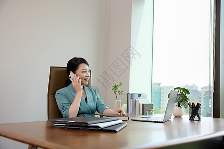 女白领坐在办公室里打电话图片