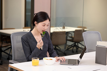 办公室里正在吃轻食的女职员图片