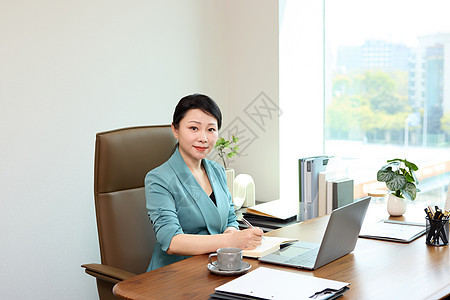 坐在办公室微笑的女老板形象图片