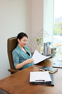 坐在办公室看文件的女老板图片