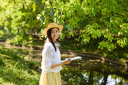 戴着草帽在森林里画画的女孩图片