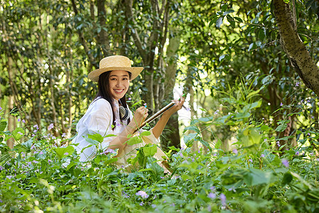 戴着草帽在森林里画画的女孩图片