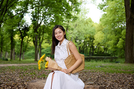 美女在森林里拿着一束花图片