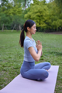 坐在瑜伽垫上练瑜伽的女性侧面照图片