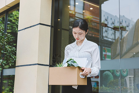 伤心的女职员抱着一箱离职物品出公司图片