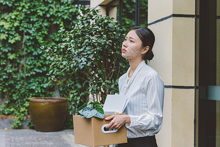 伤心的女职员抱着一箱离职物品出公司图片