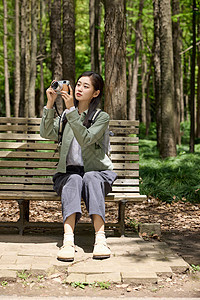 坐在公园长椅上拍摄的女性图片