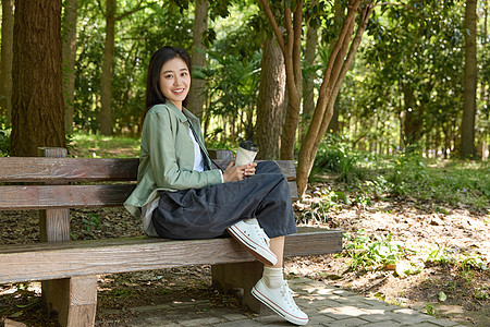 户外拿着咖啡的美女形象图片