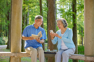 户外坐着看书玩手机的退休老人秒视频