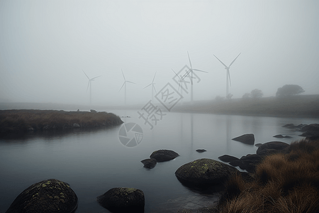 雾蒙蒙的一天，风电场的宁静景象，涡轮机部分被雾气遮盖，水反射柔和的漫射光。图片